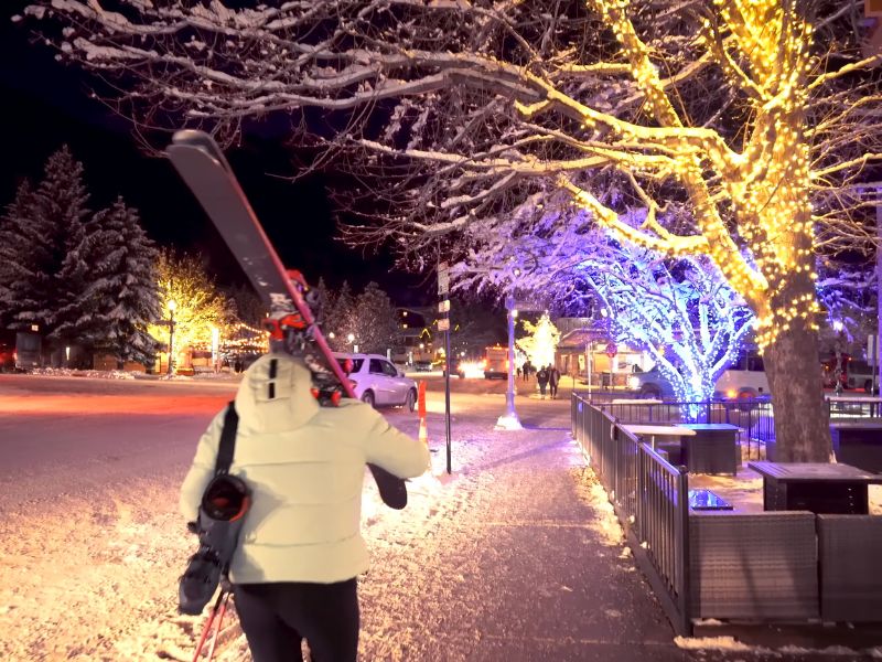 Aspen u zimskom periodu i žena koja nosi opremu za skijanje